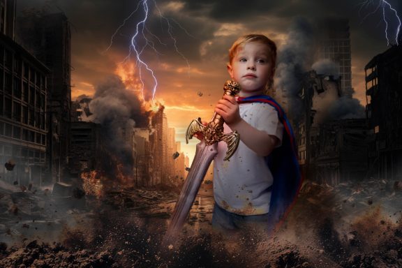 A little boy with pale skin and blonde hair dressed as a superhero, holding a sword, with a background of a destroyed city and lightening.